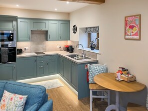 A compact kitchen with a built-in oven, a coffee maker, and a sink. - Goose Beck Cottages - Bacchus (Tockwith, near York)