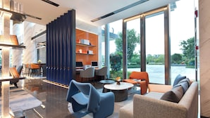 A modern interior with a seating area, a coffee table, and a view of the outdoors. - Hampton by Hilton Hangzhou Xiaoshan Jiangnan Technology City. (Hangzhou)