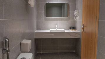 A compact bathroom with a toilet, sink, and mirror.