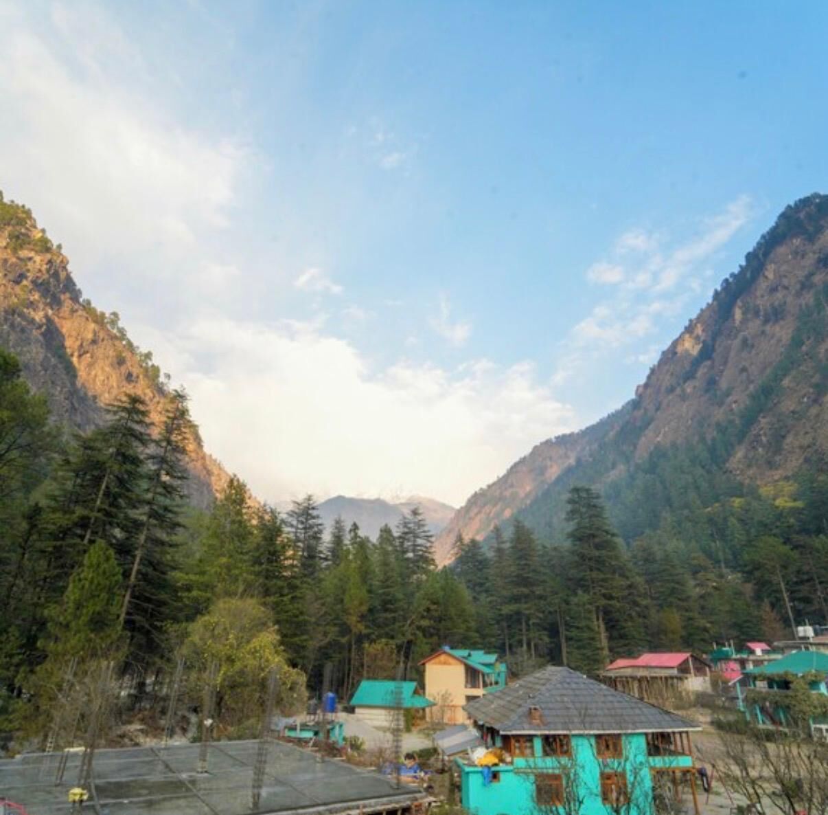 A mountainous landscape with a cluster of buildings, likely a small village or resort area.