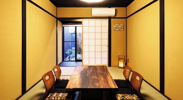 Una tradizionale stanza giapponese con pavimento in tatami, un tavolino in legno e paralumi shoji.