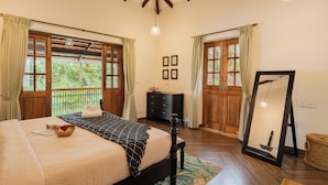 A bedroom with a bed, wooden wardrobe, and a large mirror. - ELIVAAS Celest 4 BHK Villa with Pvt Pool (Arpora)
