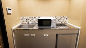 Eine kleine Küche mit Mikrowelle, Toaster und Spüle.