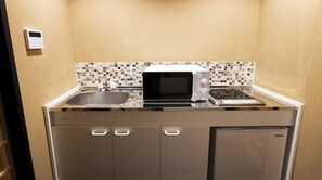 Eine kleine Küche mit Mikrowelle, Toaster und Spüle.