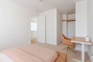 Ein Schlafzimmer mit einem Bett, einem Schreibtisch mit Stuhl und einem Kleiderschrank.