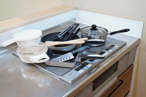 Kylskåp, mikrovågsugn, spishäll och grytor/köksredskap