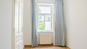 A room with a window, white walls, and a radiator. - Stylish 2BR Apartment Long Stay for 5 (Vienna)
