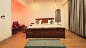 A bedroom with a wooden bed, two hanging lights, a mirror, and a view of the outside through curtains. - OnlyStay Kirpalu Dham - Opp. Prem Mandir, Vrindavan (Vrindavan)