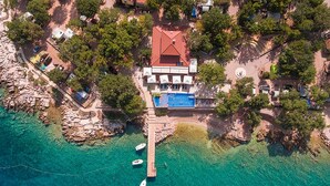 An aerial view of a coastal property with a swimming pool, dock with boats, and surrounding trees. - 2 bedroom lovely (sta)caravan in Glavotok (Glavotok)