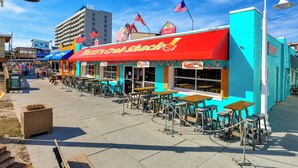 Un restaurante frente a la playa con terraza y banderas estadounidenses.