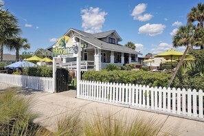 A two-story restaurant with a white picket fence, outdoor seating, and palm trees. - Steps to Boardwalk & Beach Access - Center of Town (Carolina Beach)