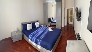 A bedroom with a bed, bedside table, and a mirror. - Charming BnB in the Heart of Ravenna in its wonderfull Green! (Ravenna)