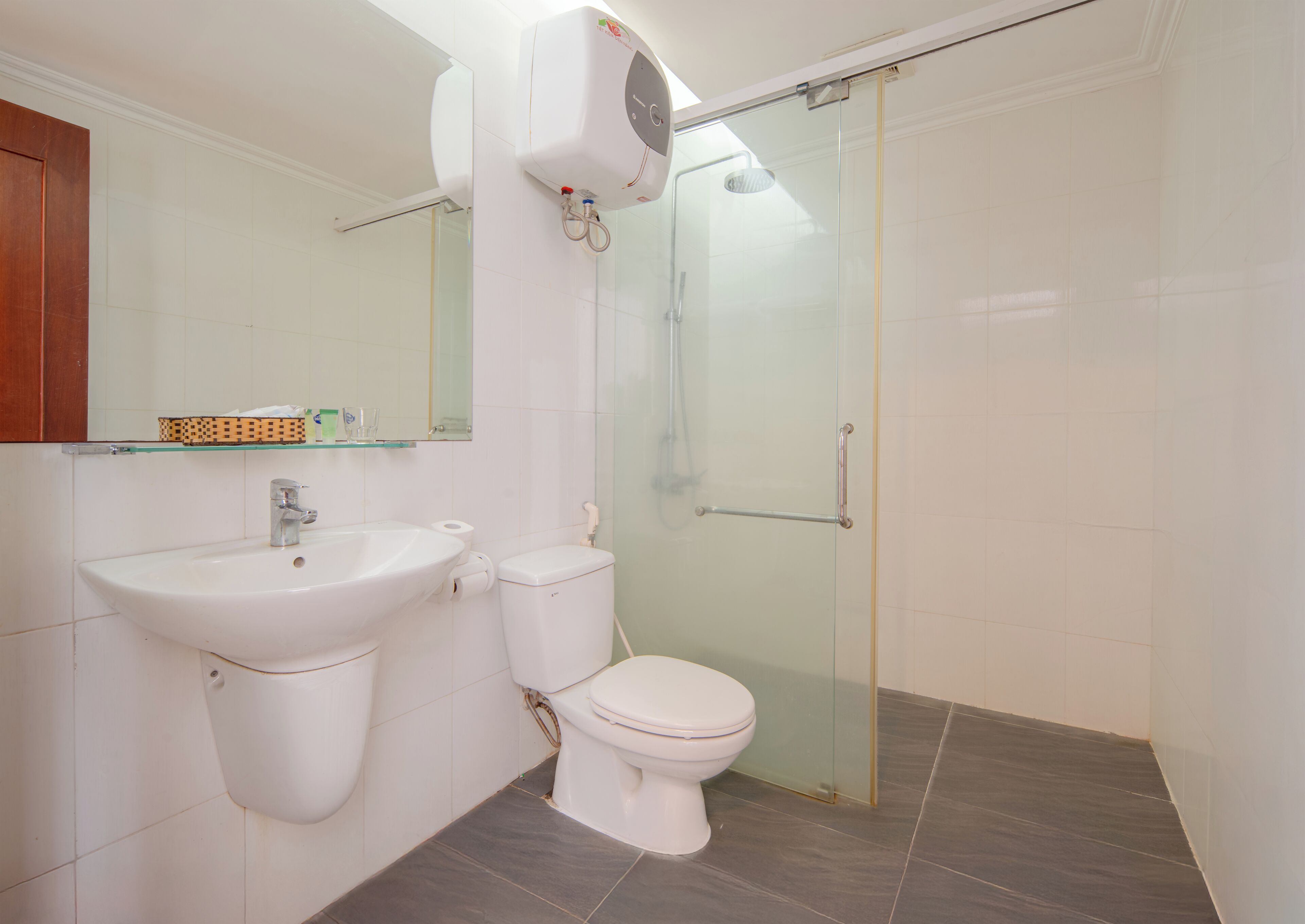 A bathroom with a sink, toilet, and glass shower enclosure.