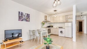 Un apartamento moderno con sala de estar, comedor, cocina y lavandería.