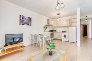 Eine moderne Wohnung mit Wohnzimmer, Essbereich, Küche und Waschraum.