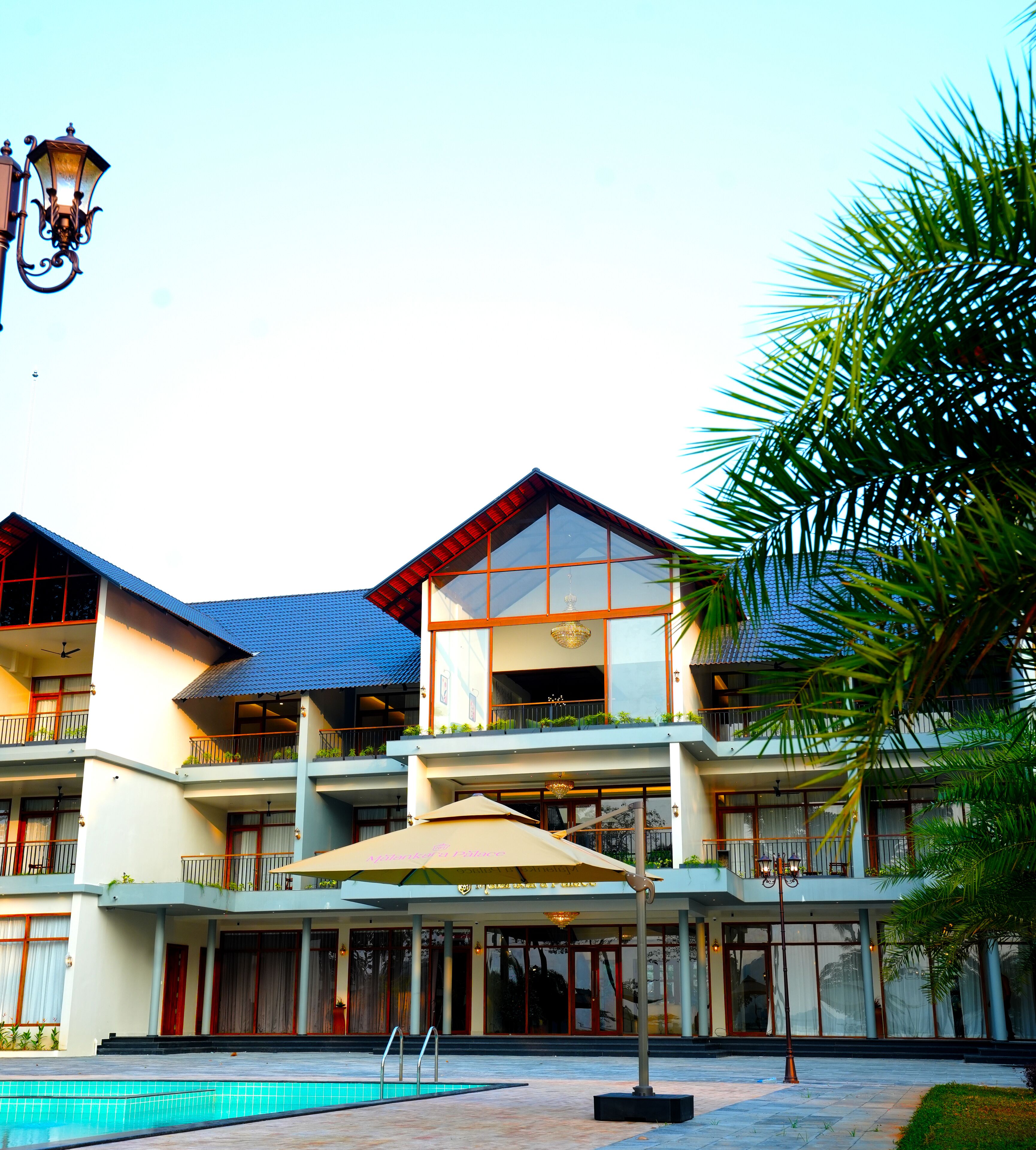 A multi-story hotel with balconies, a swimming pool, and outdoor seating.