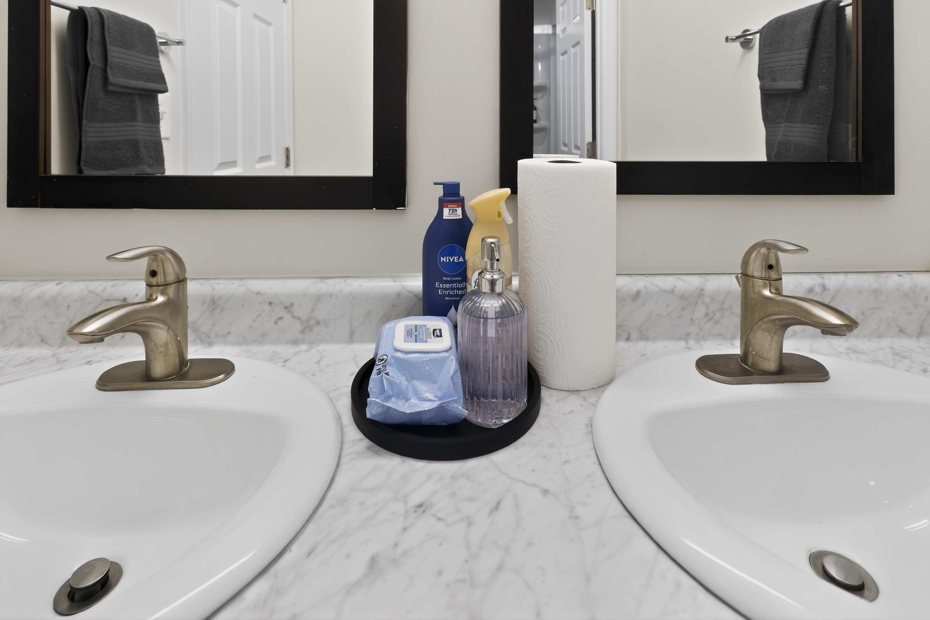 A bathroom with two sinks, a mirror, and toiletries.