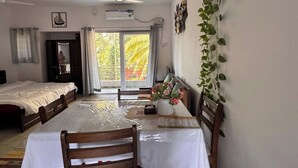 Una habitación con una mesa de comedor, sillas, una cama y un ventilador de techo.