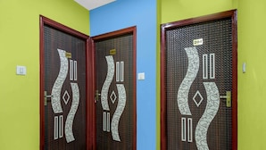 Two doors with numbers 202 and 203, a green wall, and a blue wall. - Classic The Orchid Residency (Kolkata)