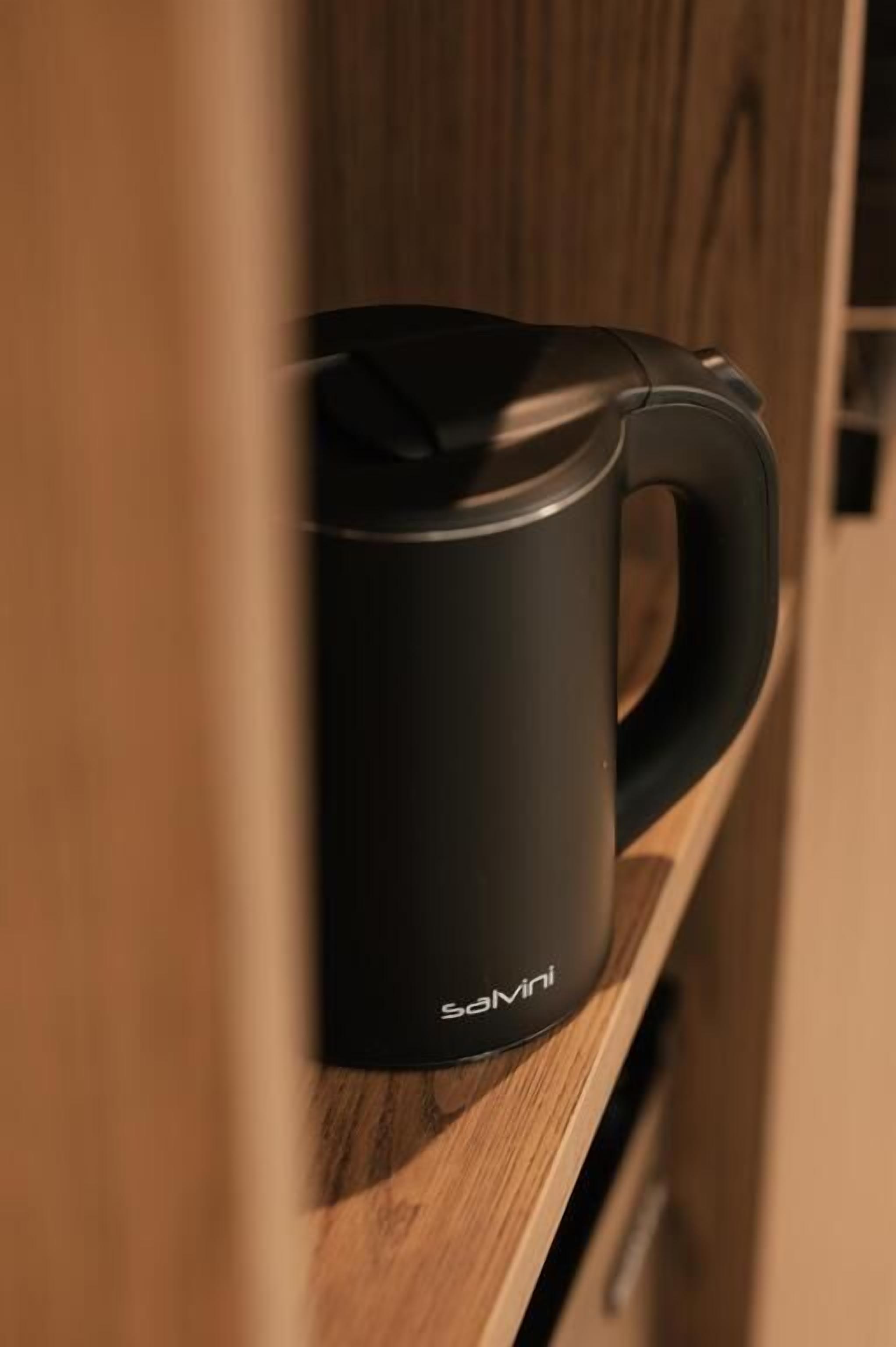 Een zwarte koffiezetapparaat op een houten aanrecht.