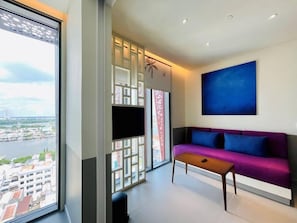 Una sala de estar moderna con un sofá, una mesa de centro y un ventanal con vistas a la ciudad.