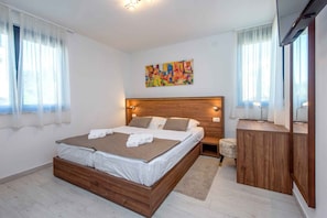 Ein modernes Schlafzimmer mit einem hölzernen Bett, einem Nachttisch, einem Spiegel und einem farbenfrohen abstrakten Gemälde an der Wand.
