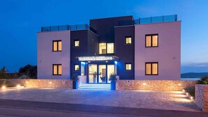 Een modern hotel met een stenen gevel, een opvallende ingang en een helder uitzicht op het omliggende landschap.
