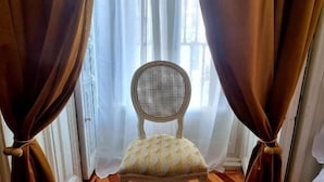A chair in front of a window with sheer curtains tied back. - Le Petit Palu Flora (Madrid)