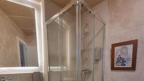 A bathroom with a glass-enclosed shower, a sink, and a toilet. - Le Petit Palu Flora (Madrid)