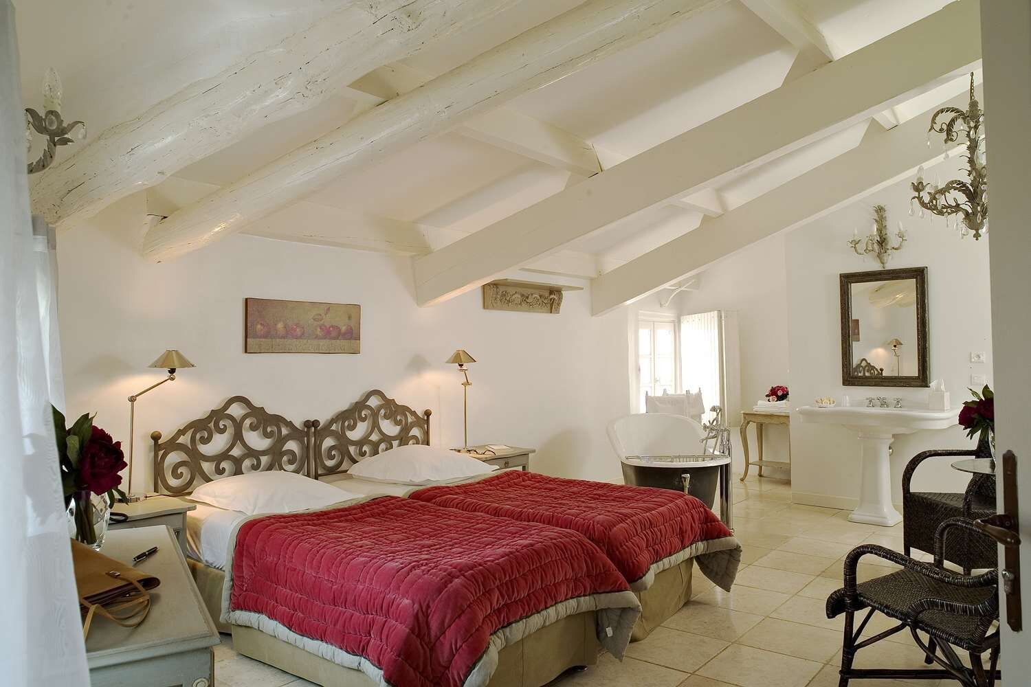 A bedroom with a bed, bedside tables, a nightstand, a dresser, a vanity with a mirror, and a chair.