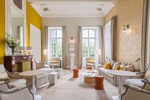 A spacious living room with a fireplace, multiple seating areas, and large windows. - Château De Mazan - Handwritten Collection (Mazan)