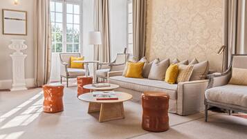 A spacious living room with a sofa, armchairs, and a coffee table.