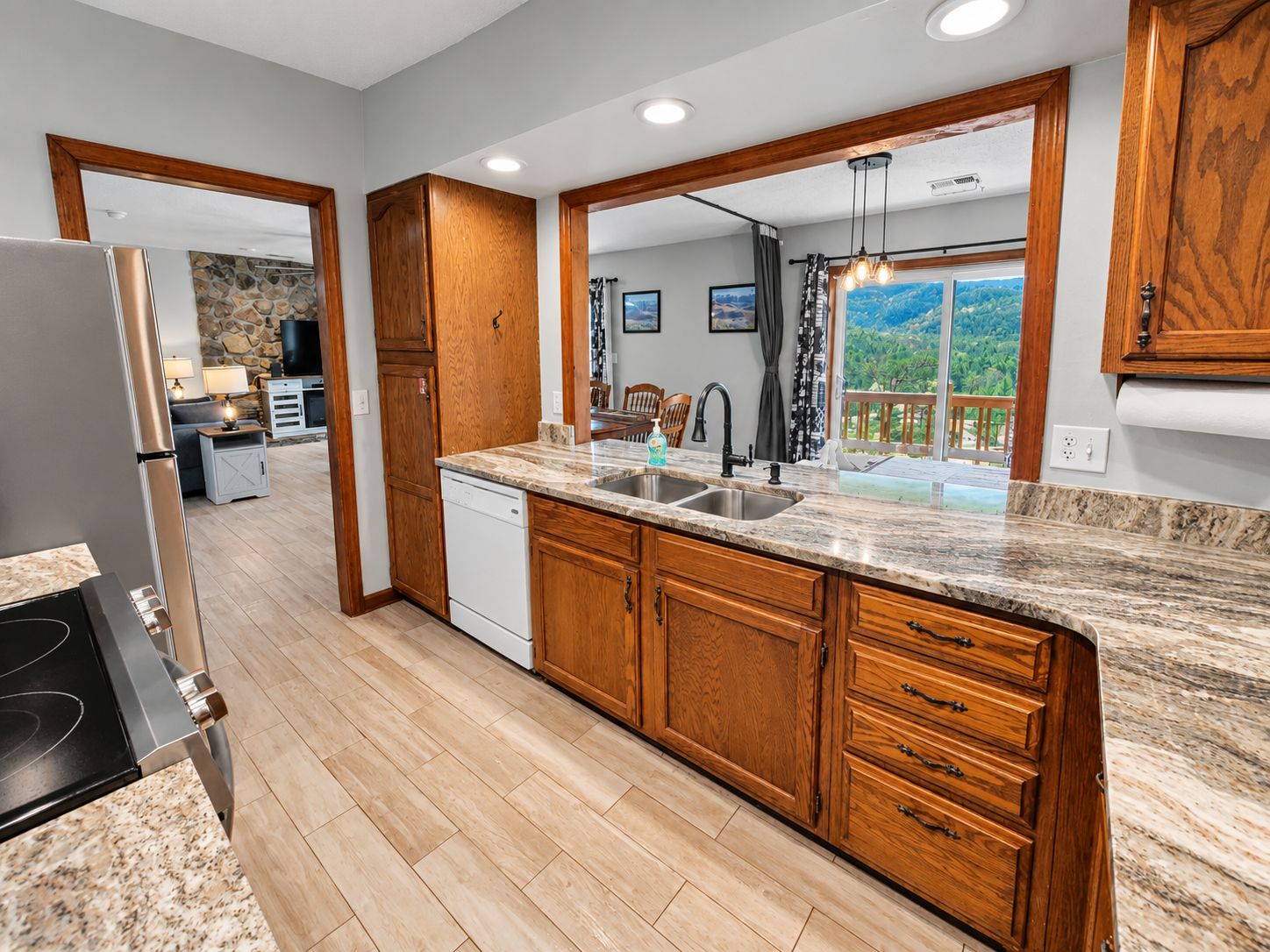 A kitchen with wooden cabinets, a granite countertop, and a dishwasher.