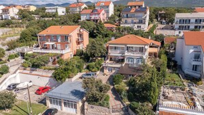 Ein Wohngebiet mit mehreren zweigeschossigen Häusern, jedes mit einem Balkon und einem roten Ziegeldach.