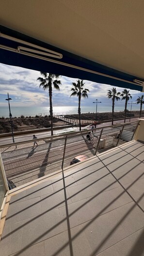 A view from a balcony overlooking a beach with palm trees, a pier, and a clear sky. - 139 Avenida Papa Luna, Peñíscola Stilmar, less than 1 minute to the beach!!!!! (Peñíscola)