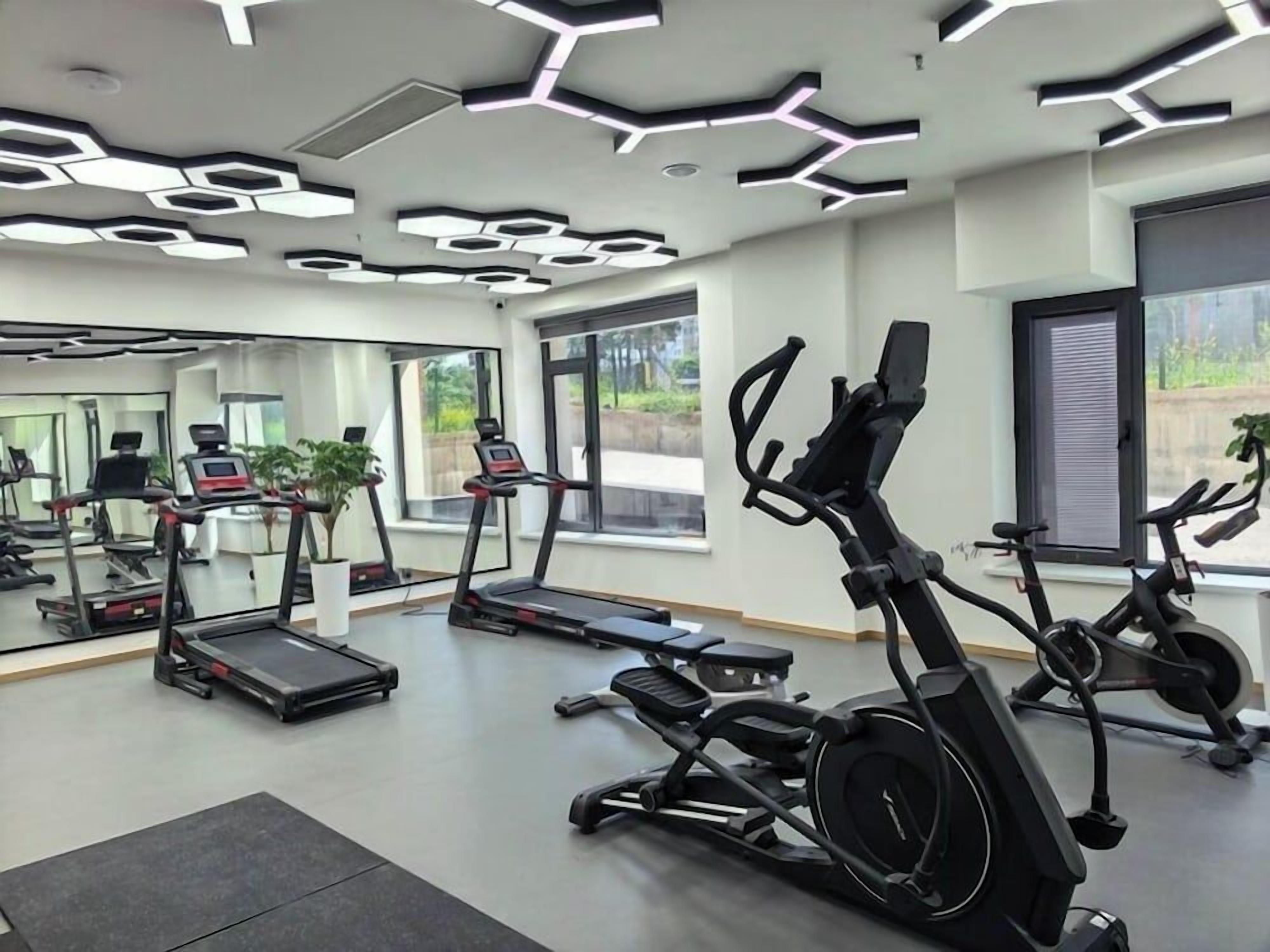 A gym with treadmills, elliptical machines, and exercise bikes.