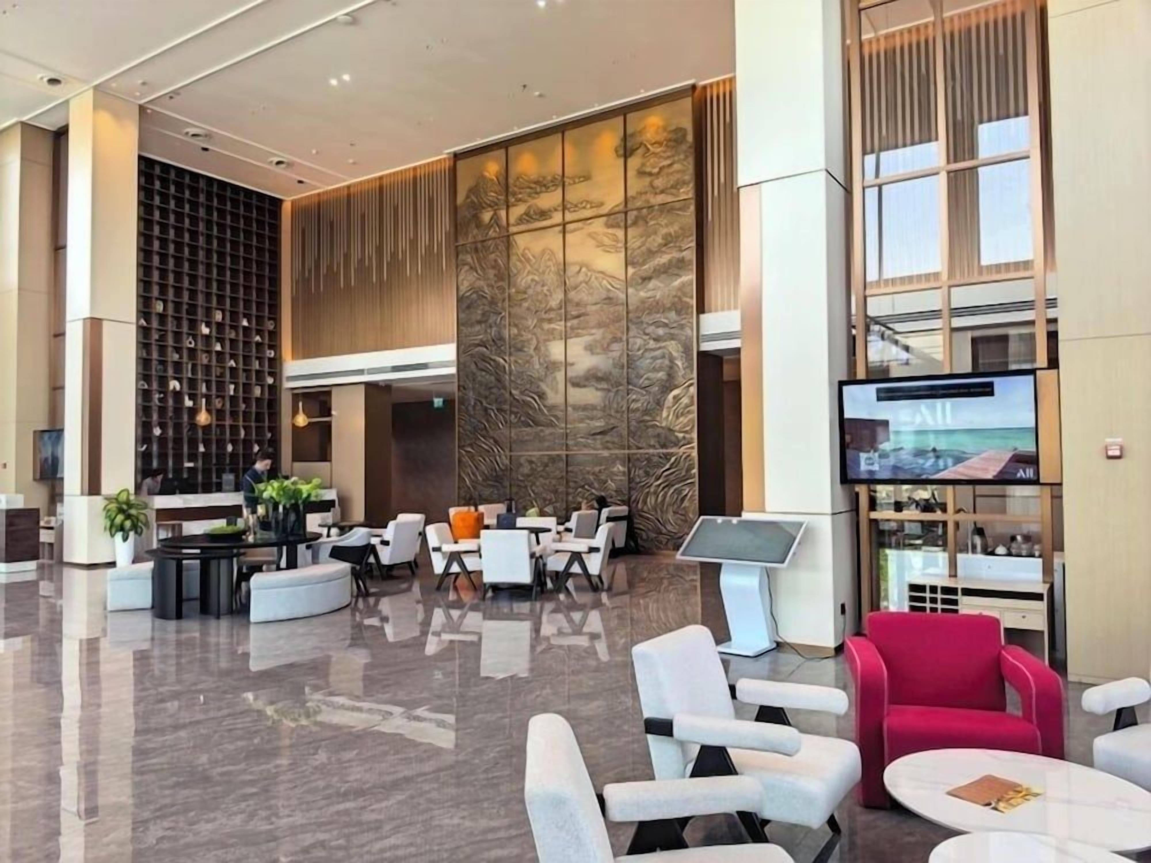 A modern lobby with a reception desk, seating area, and a large screen displaying the word 'EXIT'.