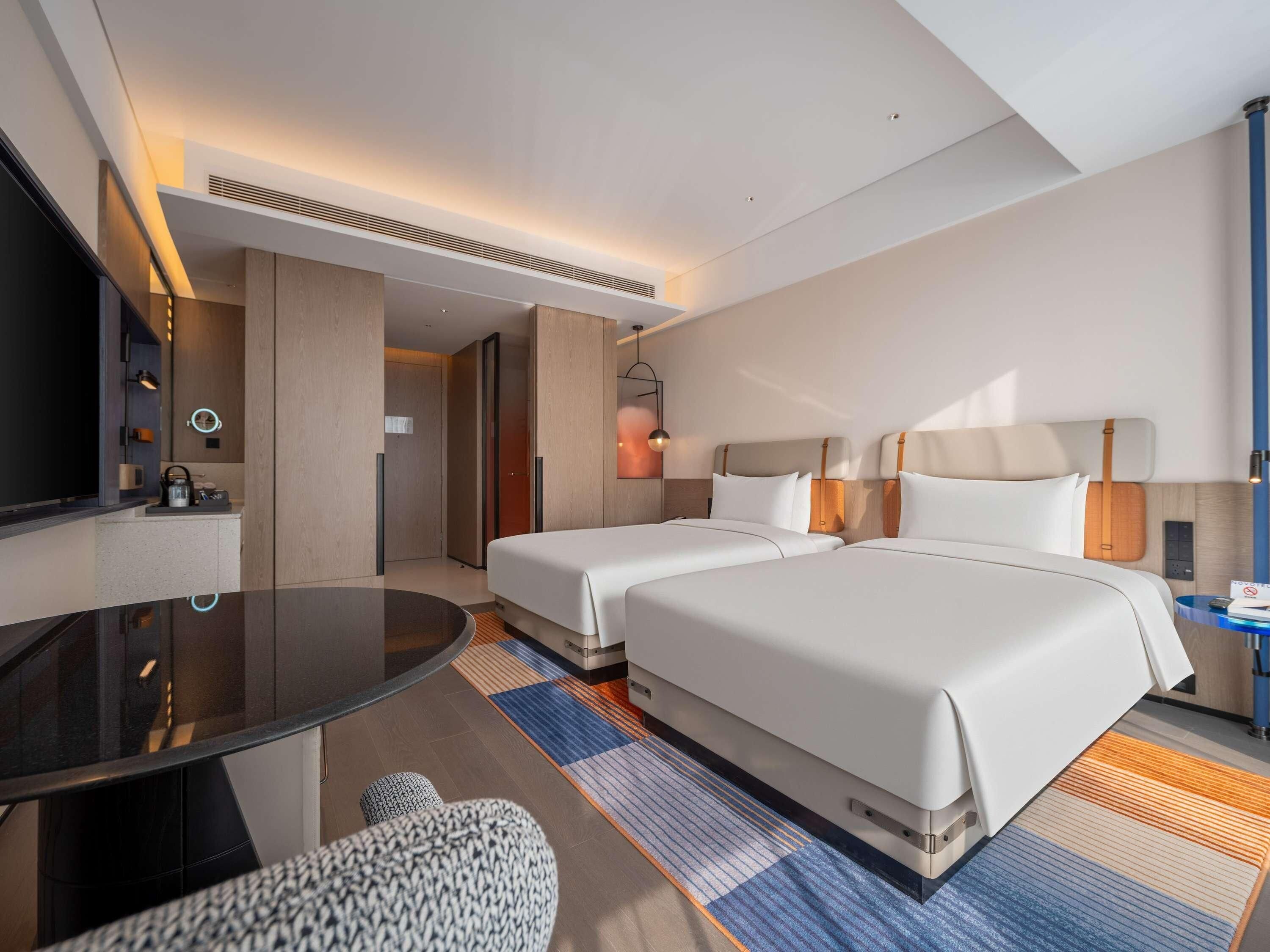 Een hotelkamer met twee bedden, een televisie, een bureau en een zithoek.