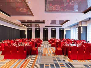 A conference room with rows of tables and chairs, large windows, and a patterned carpet. - Novotel Zibo New Hongcheng (Zibo)