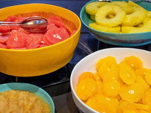 Taula amb bols plens de talls de fruita.