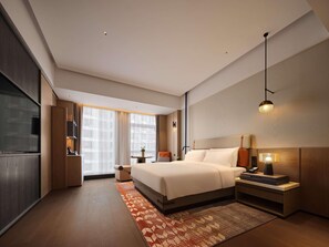 A modern hotel room with a large bed, bedside tables, a TV, and a window with curtains. - Novotel Zibo New Hongcheng (Zibo)