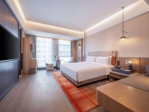 A modern hotel room with a large bed, bedside tables, a desk, and a TV. - Novotel Zibo New Hongcheng (Zibo)
