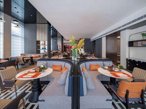A modern hotel lobby with a central seating area, tables, and a bar. - Novotel Zibo New Hongcheng (Zibo)