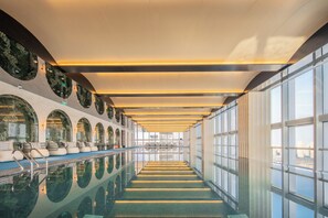 A long indoor swimming pool with a mirrored ceiling and seating area. - Sofitel Changzhou Hi-tech District (Zhenjiang)