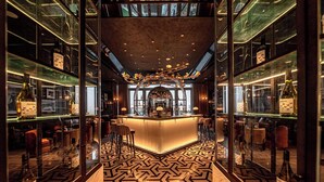 A bar area with a central counter, mirrored walls, and a patterned floor. - Sofitel Changzhou Hi-tech District (Zhenjiang)