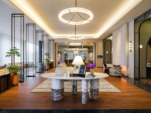 A modern hotel lobby with a marble table, seating, and a view of the city. - Sofitel Changzhou Hi-tech District (Zhenjiang)