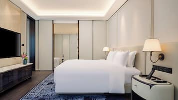 A hotel room with a large bed, bedside tables, a flat-screen TV, and a modern design.