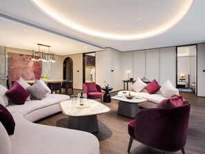 A modern hotel lobby with a curved ceiling, a seating area with sofas and armchairs, a dining table, and a large abstract painting. - Sofitel Changzhou Hi-tech District (Zhenjiang)