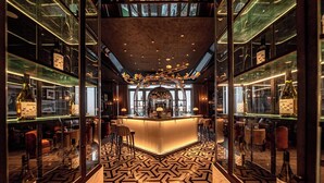 A bar area with a central counter, mirrored walls, and a patterned floor. - Sofitel Changzhou Hi-tech District (Zhenjiang)