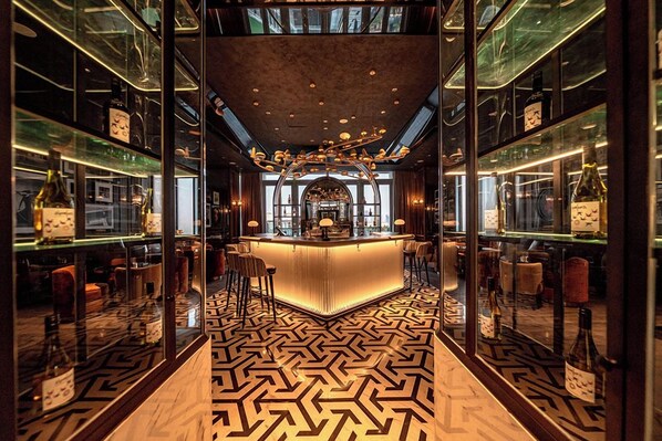 A bar area with a central counter, mirrored walls, and a patterned floor. - Sofitel Changzhou Hi-tech District (Zhenjiang)
